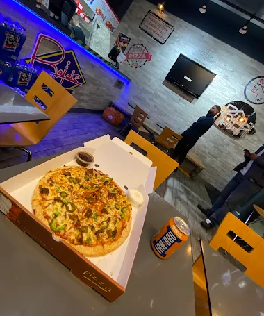 A fresh pizza topped with vegetables and sauces in a pizza box at Raja’s Pizza Bar in Glasgow.